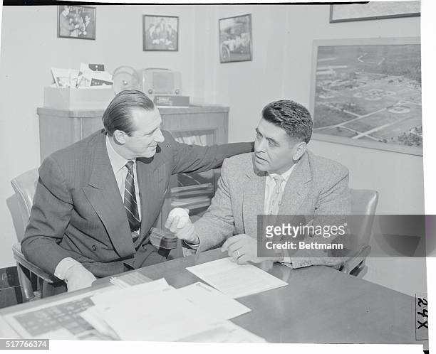 General Manager Hank Greenberg signs pitcher Mike Garcia to an Indian contract in Cleveland Stadium offices. Mike led the American League in 1954 in...
