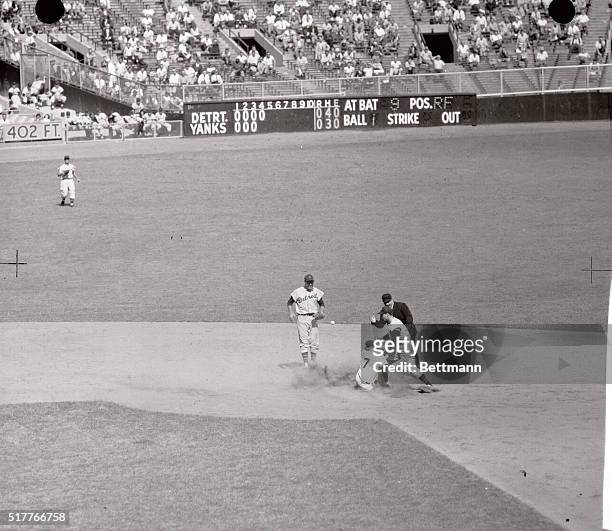 Mickey Mantle makes it into second base on a safe slide in this fourth inning action in Yankees-Detroit tigers game after Fred Hatfield missed...