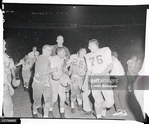Jubilant Notre Dame players carry coach, Terry Brennan, after a 14-0 victory over Miami University in front of the largest crowd to witness a...