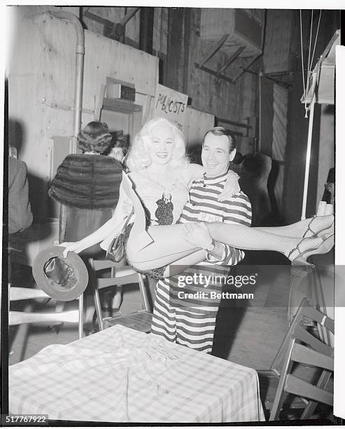 Ray Anthony dressed as a convict and his wife Mamie Van Doren in a show girl costume are shown enjoying themselves at the Ballyho Ball given by the...