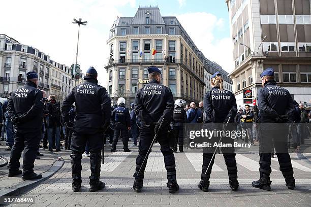 Police officers stand guard as right-wing self-described hooligans arrive for a demonstration on Place de la Bourse on March 27 in Brussels, Belgium....