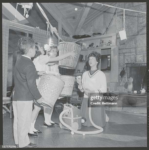 In this birthday game, an older sister holds a ping-pong ball over the vacuum hose nozzle. When she lets go, the three children try to catch the ball...