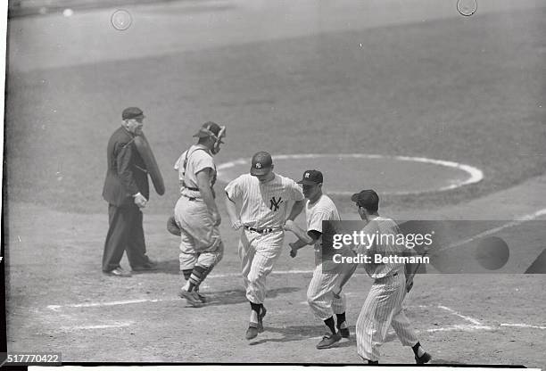 Mickey Mantle is greeted at the plate by Yankee teammate enos slaughter who was scored by the round-tripper in the second inning of today's opener of...