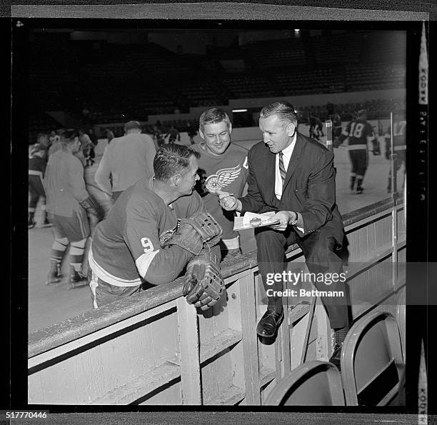 Huddling on opening day of the 1962 Detroit Red Wing training camp 9/8 are Manager/Coach Sid Abel , Assistant Coach and right winger Gordon Howe and...