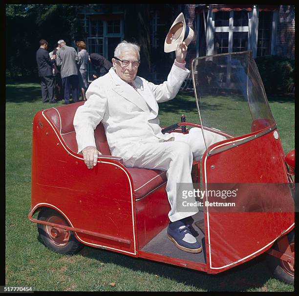 Bernard Baruch is shown here waving from a vehicle in Old Westbury, Long Island. | Location: Old Westbury, Long Island, New York, USA.