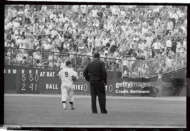 New York Yankees' right fielder Roger Maris and first base umpire Ed Runge look into right field stands during the second game of a doubleheader...