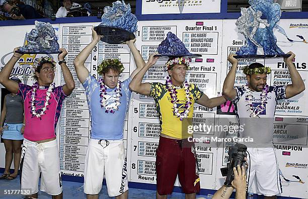 The finalists of the Vans Triple Crown of Surfing hold their trophies after the championship November 22, 2004 at Ali'i Beach Park in Haleiwa,...