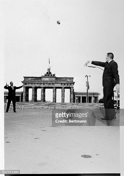 Baltimore Colts stars, Johnny Unitas and Gino Marchetti, play catch in front of the Brandenburg Gate in West Berlin. The two, along with Head Coach,...