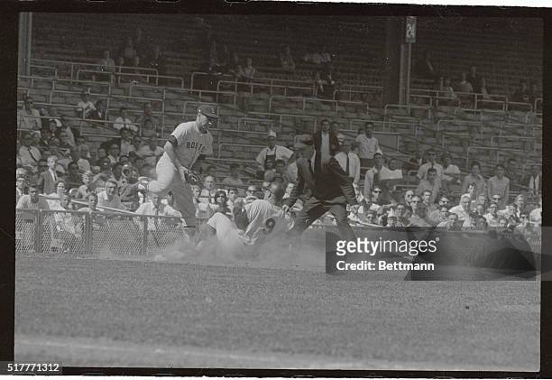 Roger Maris slides safely into third on Tom Tresh's hit to right field as Boston Red Sox third baseman Frank Malzone gets a late throw from...