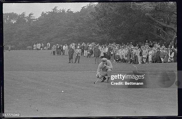 Arnold Palmer studies the lay of his ball, as his famed "Arnie's Army," watched in the background, on the 2nd green and the third round of the Lucky...