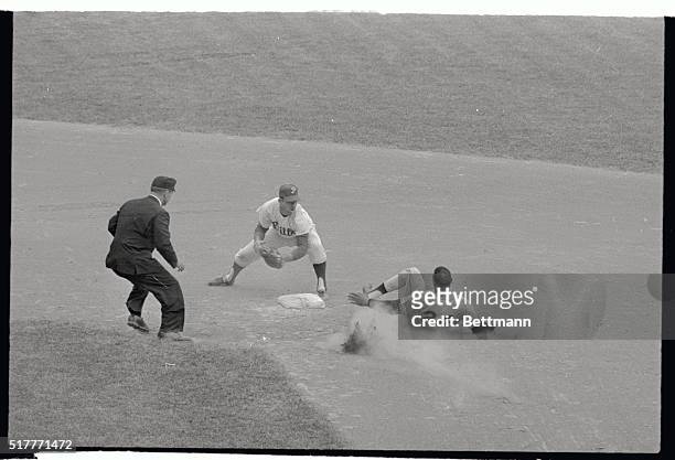 Giant's Willie Mays is out in a cloud of dust here, as he tried to stretch a hit to Phillies leftfielder Wes Covington into a double in the eighth...