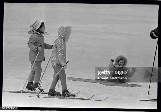 Caroline Kennedy smiles here after taking a tumble while skiing down beginners' slope on Mt. Mansfield. Coming to her aid are Mary Shriver, , and...