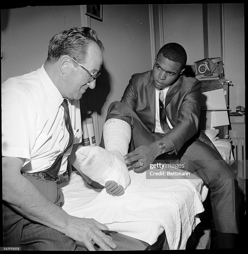 Gale Sayers Discusses His Cast With a Trainer