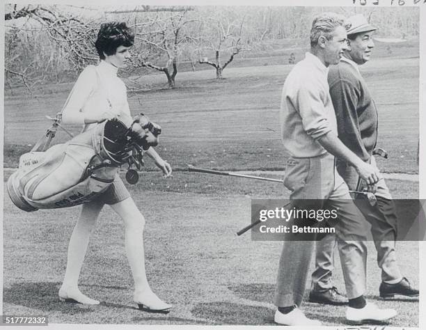 Miniskirted caddy Susan Campbell follows club pro Paul Harney and Band leader Louis Prima as the two men get in some Spring golfing at the Pleasant...