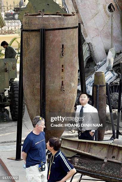 Local and foreign visitors walk around what is claimed to be the biggest ever detonated US bomb left over after the Vietnam War on display at the...