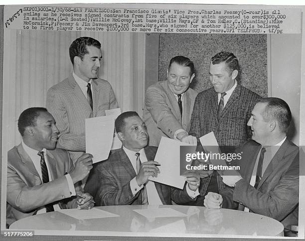 San Francisco Giants' Vice President Charles Feeney is all smiles as he receives signed contracts from five of six players, which amounted to over...