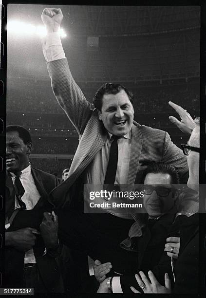 Houston basketball coach Guy Lewis is carried from the court by happy fans after his Cougars upset the number one UCLA Bruins 71-69. Number two...