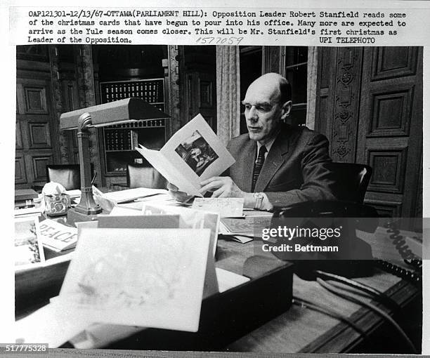 Ottawa, Canada- Opposition Leader Robert Stanfield reads some of the Christmas cards that have begun to pour into his office. Many more are expected...