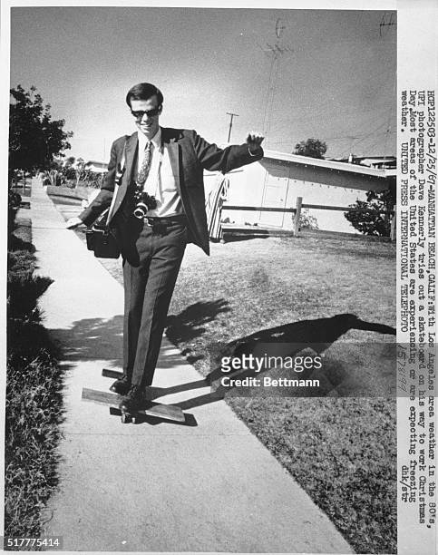 With Los Angeles weather in the 80's, UPI photographer, Dave Kennerly, tries out a skateboard on his way to work Christmas Day. Most of the US is...