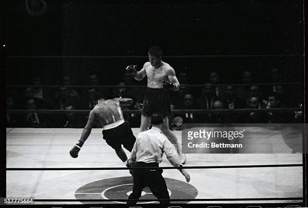 Thad Spencer goes down from a right to his chin by Jerry Quarry in the fourth round of their heavyweight elimination bout. In the foreground is...