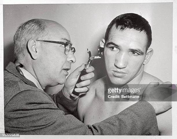 Middleweight contender Gene Fullmer is shown being examined at Roon's Gym today. Fullmer hopes to cop the title from champion Sugar Ray Robinson when...
