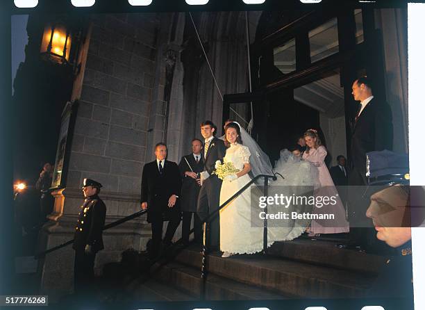 David and Julie Eisenhower leave the Marble Collegiate Church following their marriage. Her sister, Tricia Nixon holds the gown's train.