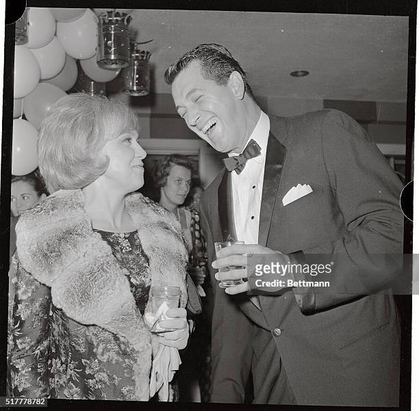 Actress Edie Adams and actor Rock Hudson share a laugh during pre-dinner cocktailing at a party which gave for recently married Jack Lemmon and...