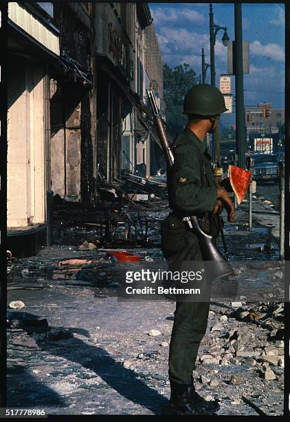National Guardsman takes a watermelon break while standing in the rubble of damaged buildings on Detroit's west side. This is an area devastated by...