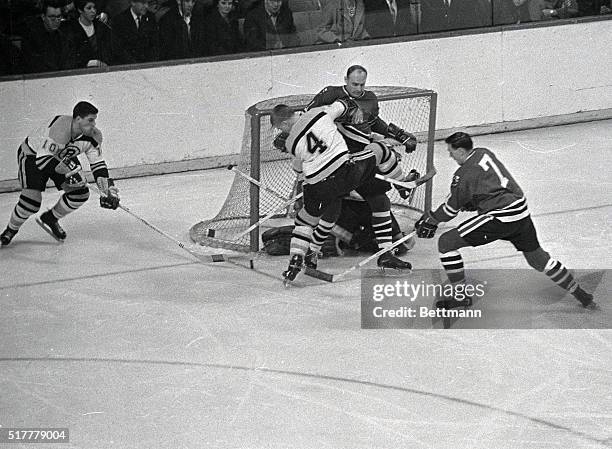 Bruins' defenseman Bobby Orr crashes into Hawks' Doug Mohns as he eyes puck rolling dangerously close to the goal's mouth in first period action at...