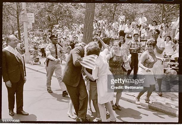 New York's Democratic Senator Robert F. Kennedy is kissed and embraced by passionate Puerto Rican supporters June 4th, along the Fifth Avenue route...