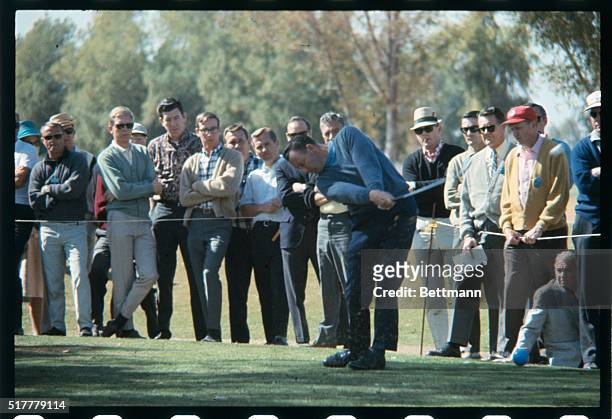 Phoenix, AZ: Golfer Billy Casper- at the Phoenix Open. Also shown with golfer Don January, as they pause on the 7th green while plane flies overhead.