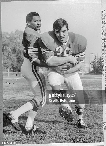 East squad quarterback James Rays, of Michigan State hands off to Larry Csonka, Syracuse fullback, during recent camera day session. The East is...
