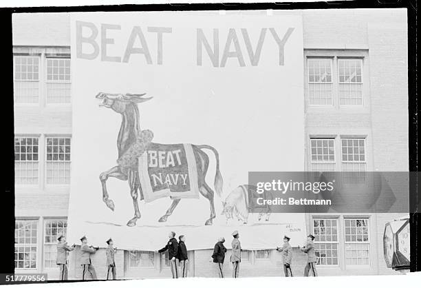 West Point cadets unfurl a huge "Beat Navy" banner on one of the cadet barracks. Army meets Navy in their traditional grid contest on December 2nd in...