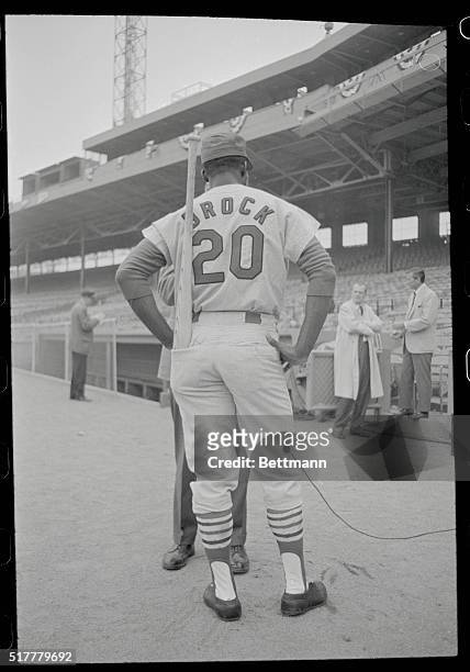 Boston, Massachusetts: St. Louis Cardinals Lou Brock finds a new resting place for his bat as he talks with a reporter during batting practice. The...