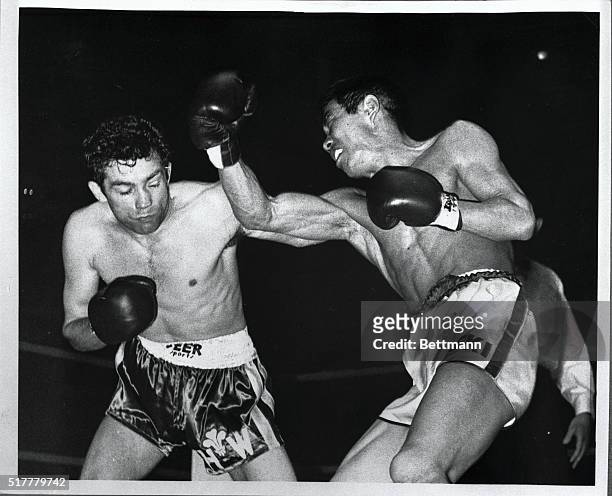 Japan's Mitsunori Seki swings a right at Britain's Howard Winstone during the first round of their world featherweight championship fight at London's...