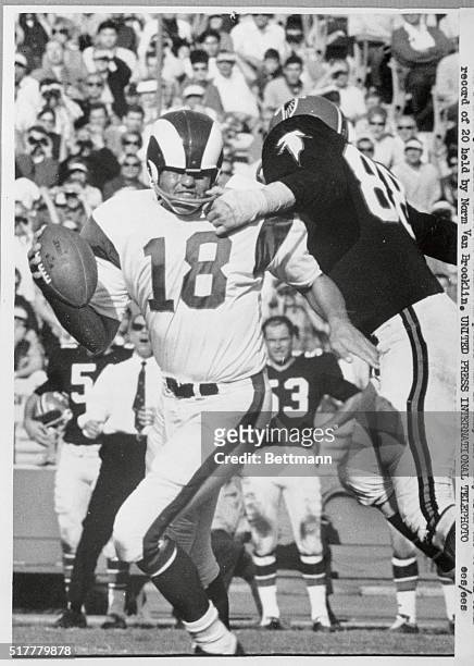 Ram quarterback Roman Gabriel has his helmet pulled down over his eyes by Sam Williams of the Falcons as he attempts to throw a pass. Gabriel was...