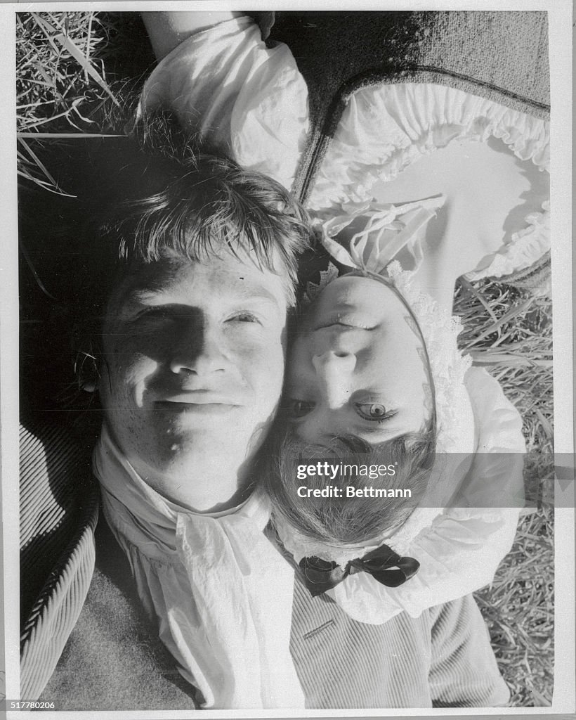 John Hurt and Pamela Franklin Laying on Grass