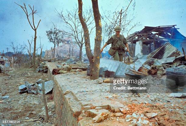 The body of a dead Viet Cong soldier lies amid the wreckage of a house that was leveled by U.S. Marines after it was determined that Communists were...
