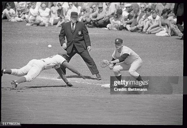 Senators outfielder Fred Valentine beats the ball back to first base where Yankee slugger Mickey Mantle waits for the pickoff attempt during the...
