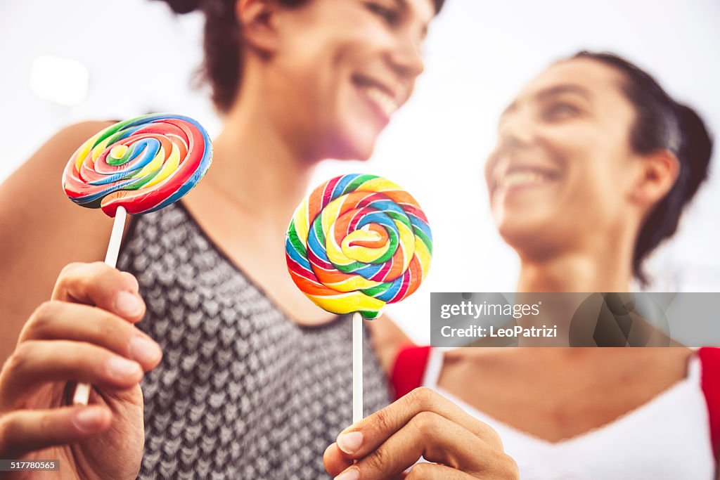 Friends with lollipop at amusement park