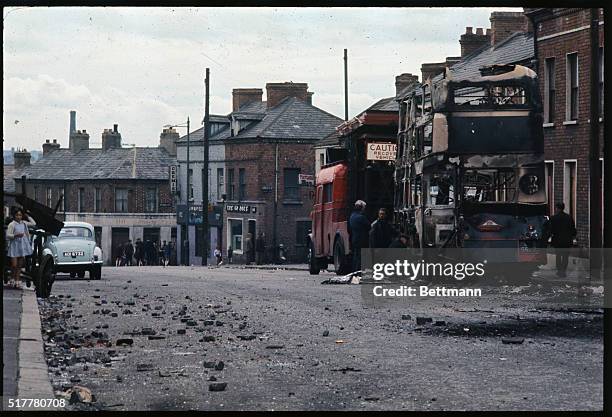 This scene in the Falls Road area of Belfast shows burned out buses in the street.