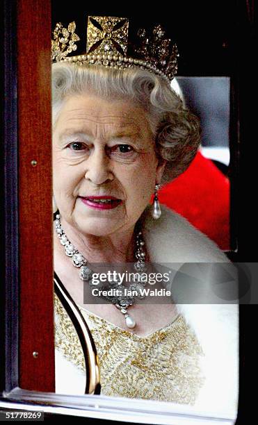 Queen Elizabeth II looks out of the window of her carriage as ahe arrives for the state opening of Parliament November 23, 2004 in London. In her...