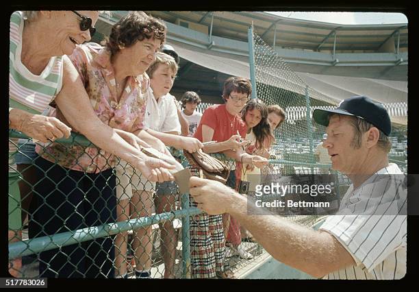 Mickey Mantle, member of baseball's Hall of Fame, signs autographs for fans young and old at the New York Yankee's spring training camp.