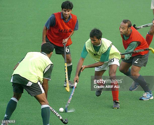 Pakistani field hockey player Akhtar Ali dribbles the ball in front of his teammates during a practice session at National Hockey Stadium in Lahore,...