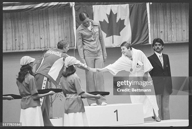 Montreal: East Germany's gold medal winner Ulricke Tauber watches as Cheryl Gibson the silver medal winner, shake hands with her teammate Becky...
