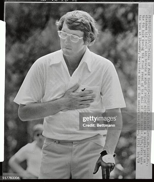 Hale Irwin, of St. Louis, MO, clutches his heart and breathes a sigh of relief after sinking a birdie putt on the 4th hole during the final round of...