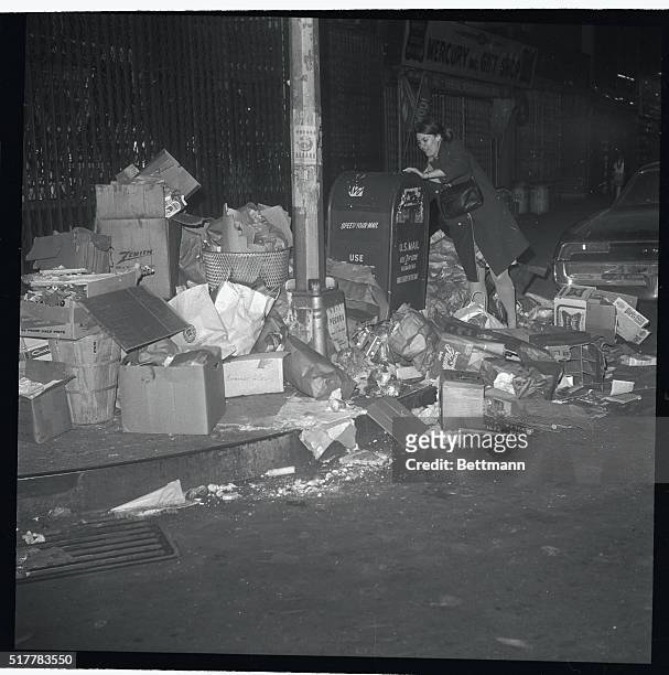 Manhattan resident wades through piles of trash to mailman letter on February 6th, as the strike by Department of Sanitation employees, now in its...