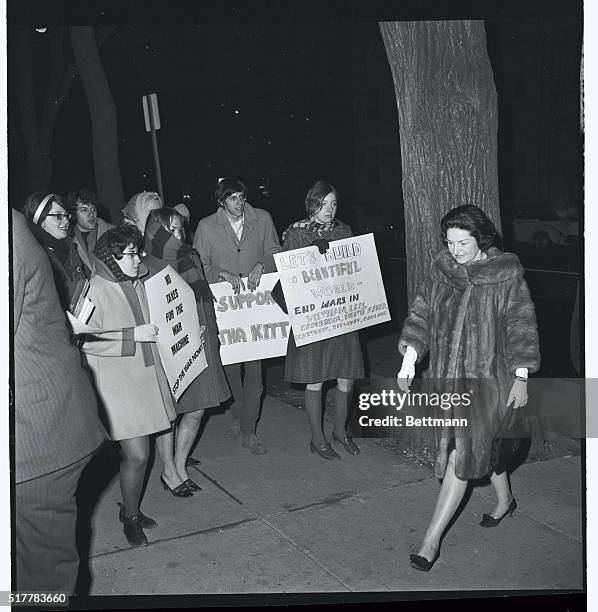 Photo shows Mrs. Lady Bird Johnson as she walks past a group of youthful picketers, as she arrives at the National Press Club today. The First Lady...