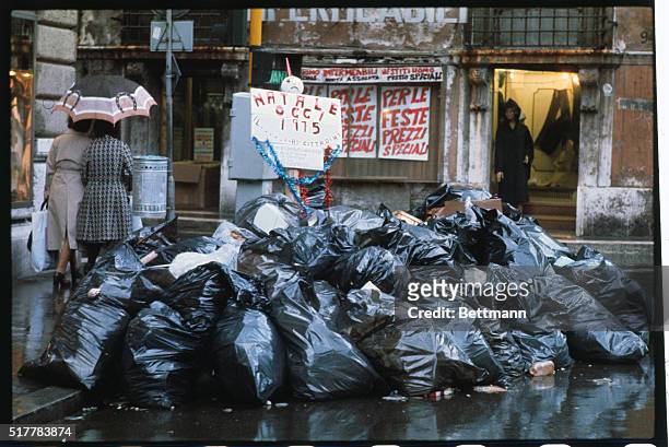 Bags of garbage pile up in a Rome street on the fourth day of a garbage collectors' strike. An ironical "Christmas today: sign advises the Christ...