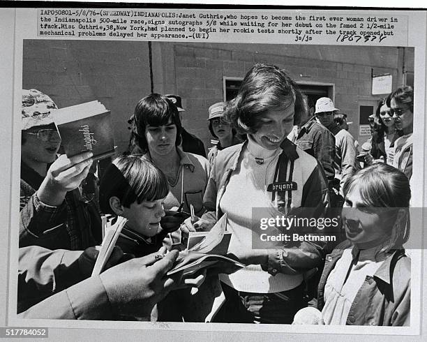 Janet Guthrie, who hopes to become the first ever woman driver in the Indianapolis 500-mile race, signs autographs 5/8, while waiting for her debut...